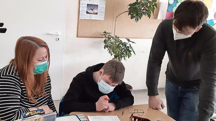 Auch Nils muss Maske tragen. Über die Schulter schauen ihm seine Schulbegleiterin Janine Schröter und sein Klassenlehrer Marco Jahns.