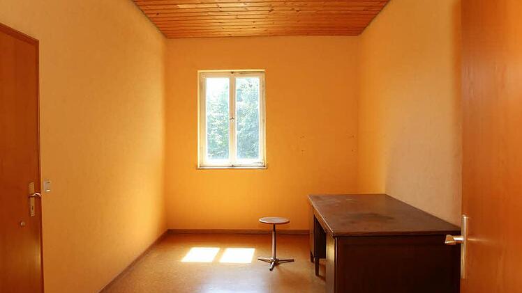 Heller Raum mit dunklem Schreibtisch.