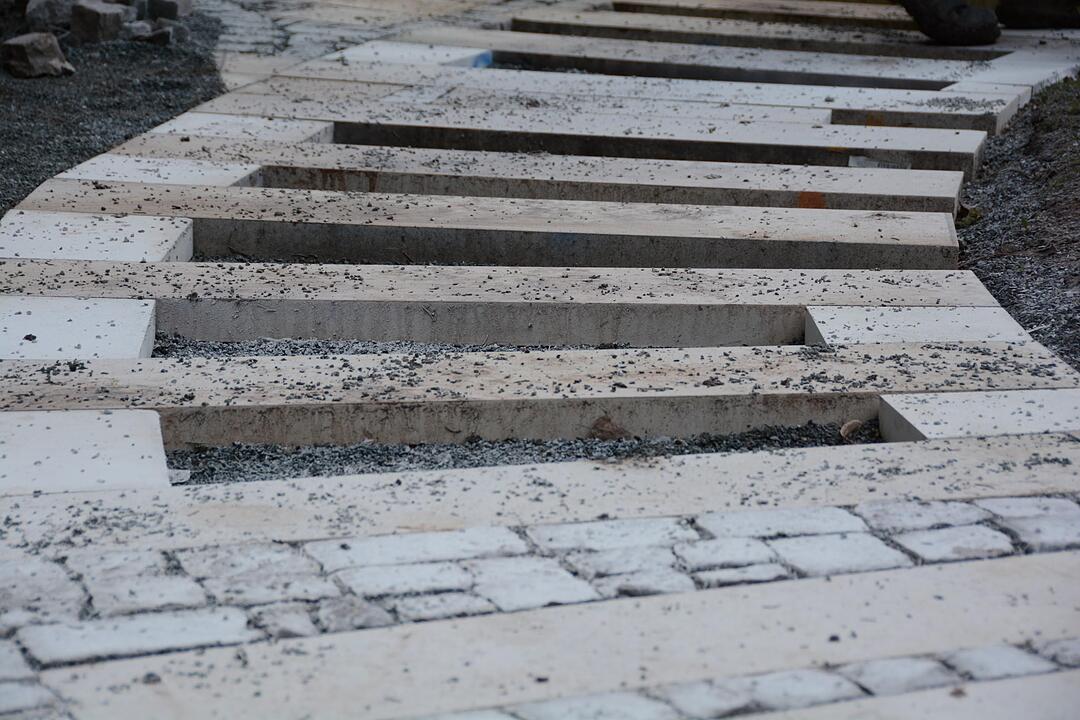 Unser Gartenweg: Die Felder zwischen den großen Platten werden mit kleinem Pflaster aus unterschiedlichen Natursteinen aufgefüllt.