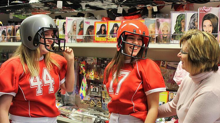 Viel Spaß unter dem Footballhelm haben Sophia Schick (von links)  und Clara Gräf . Elke Bocklet berät bei der Auswahl. Foto: Werner Vogel