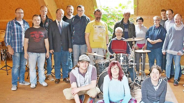 Strahlende Gesichter der Band und der Sponsoren am Freitagnachmittag im Probenraum der Behinderteneinrichtung Maria Bildhausen. Alexander am Drumset konnte es noch gar nicht fassen, dass das alles nun in der Gruppe bleibt. Das war ihm einen langanhaltenden Trommelwirbel wert. Mit auf dem Bild, neben den Sponsoren, auch der Gesamtleiter des Dominikus-Ringeisen-Werks Maria Bildhausen, Rainer Waldvogel (4. von links). Ebenso Bandleader Klaus Schmitt (rechts).  Foto: Friedrich