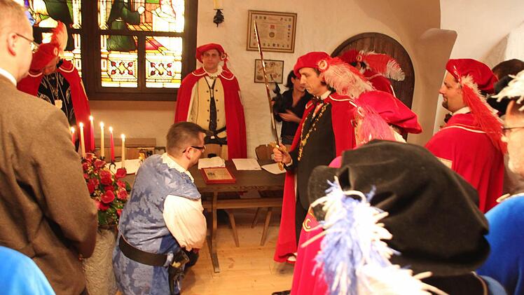 Thomas Pohl (kniend) erhält den Ritterschlag von Großmeyster Sigi. Foto: Friedwald Schedel