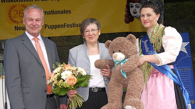 Heidrun Piwernetz (Mitte) bekam von Frank Rebhan und der Neustadter Puppenfee zur Er&ouml;ffnung des Puppenfestivals einen Teddyb&auml;ren geschenkt. Foto: Berthold K&ouml;hler