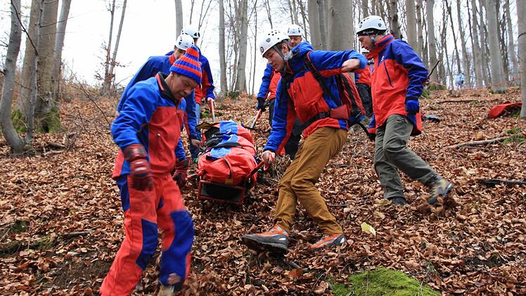 In einer Gebirgstrage schafften die Retter der Bergwacht das Opfer den steilen Hang hinunter.