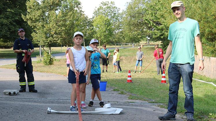 Bei einer Station galt es, beim Ausrollen des Schlauches die "Kegel" umzuwerfen. Foto: Janina Reuter-Schad