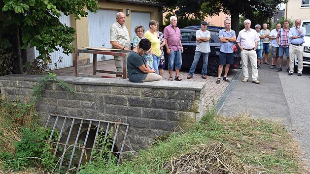 Der Gemeinderat Theres war mehrere Stunden auf Besichtigungstour, um sich ein Bild von den Problemen bei Starkregen zu machen und Lösungen zu suchen. Im Bild der Rechen am Riedengraben am "Rentnerweg" der immer schnell mit Ästen und Gras verstopft ist.  Ulrike Langer