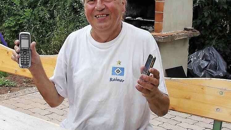 Weder schnurloses Telefon (links) noch Handy funktionieren im Garten des bekennenden HSV-Fans Reiner Ebert in Burgrub. Der langjährige erfolgreiche Fußballer des FC Burggrub trägt das T-Shirt mit dem Hamburger Logo und seinem Namen mit Stolz. Foto: Friedwald Schedel