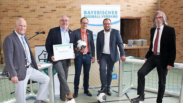 Der Kreisehrenamtsbeauftragte Siegfried Tabbert hatte nicht nur die Urkunde f&uuml;r den "Club 100", die er an Achim Br&uuml;ckner &uuml;berreichte, im Gep&auml;ck, sondern auch zwei Minitore und f&uuml;nf Trainingsb&auml;lle, die er zusammen mit einem Ballsack &uuml;berreichte. Von links: Siegfried Tabbert, Achim Br&uuml;ckner, Bastian B&uuml;ttner, Landrat Sebastian Straubel und B&uuml;rgermeister Martin Rauscher  Foto: Michael Stelzner