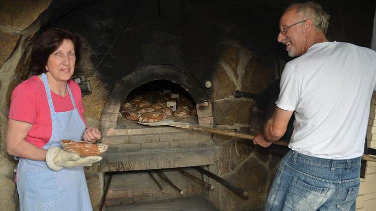 Bernhard und Gertrud Fößel arbeiten gemeinsam Hand in Hand beim Holzofenbrot backen. Foto: Karl-Heinz Hofmann