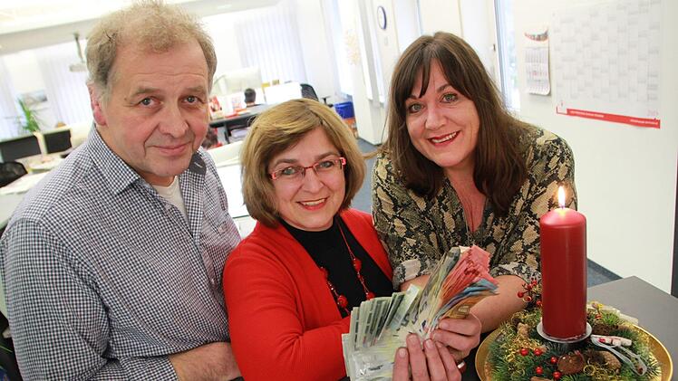 Chorleiter Ewald Müller und Michaela Atzler vom Chor Harmonie 1910 Arnshausen übergeben Redaktionsleiterin Susanne Will über 715 Euro. Foto: Carmen Schmitt
