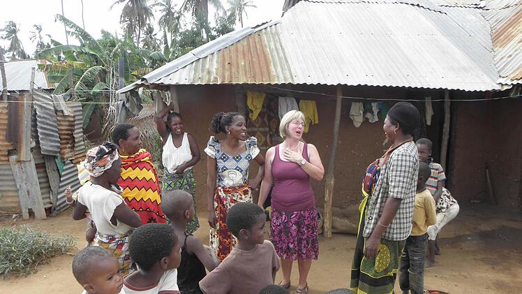 Anneliese Friedel, die Frau von Werner Friedel, im lebhaften Gespräch mit den Erzieherinnen und Kindern der Kindergärten der Pfarrei St. Paul in der tansanischen Diözese Mtwara. Die Aufnahme gibt einen Einblick in die Wohn- und Lebensverhältnisse der Einheimischen in dem afrikanischen Land.  Foto: mw