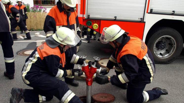 Die Feuerwehr Wallenfels beim Setzen des Strahlrohrs auf den Unterflurhydranten.