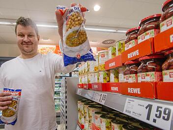 Ungeahnter Verkaufsschlager: Stefan Helmreich, geschäftsführender Gesellschafter des Rewe-Markts in Ebelsbach, zeigt, was in den Tagen vor Weihnachten besonders oft aufs Kassenfließband gelegt wird - Backerbsen. Den vielen Vorspeisen-Suppen sei Dank. Foto: Marian Hamacher