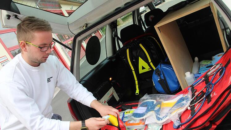 Julian Klinke kontrolliert das Equipment im Kofferraum des Einsatzfahrzeugs, dazu geh&ouml;ren unter anderem Verbandsmaterial, Sauerstoff, ein Defibrillator und Ger&auml;te zur Beatmung. Das Material muss regelm&auml;&szlig;ig gewartet und nach Ablauf ausgetauscht werden. Cindy D&ouml;tschel