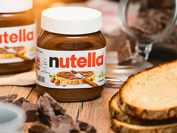 Ein Glas Nutella und ein bestrichenes Brot