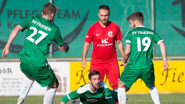 Friesens Abwehrspieler Andreas Baier wirft sich in den Ball, auf den der zweifache Torsch&uuml;tze G&ouml;khan Aydin (rotes Trikot) wartet.  Foto: Heinrich Wei&szlig;