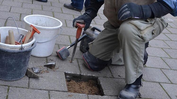 Gunter Demnig beim Einbau der drei Stolpersteine in den Gehweg.