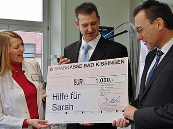 Einen Spendenscheck über 1 000 Euro überreichten Cornelia Pape, Leitende Oberärztin der Klinik am Kurpark, und der kaufmännische Leiter Holger Metz (Mitte) an Auras Bürgermeister Thomas Hack für die an Leukämie erkrankte Sarah in Aura. Foto: Dobschütz