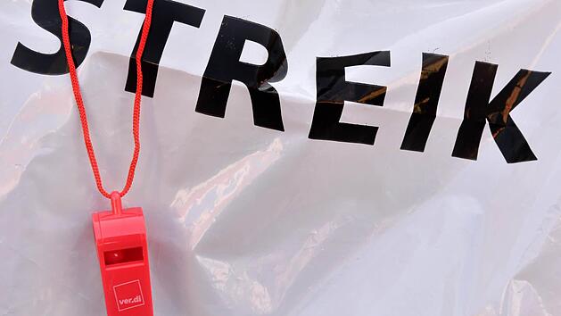 Eine rote Trillerpfeife hängt während einer Demonstration zum Kita-Warnstreik in Bayern vor dem Schriftzug "Streik". Für die Woche vom 18. bis 22.04.2016 wurden weitere Warnstreiks angekündigt. Foto: Peter Kneffel/dpa