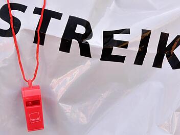 Eine rote Trillerpfeife hängt während einer Demonstration zum Kita-Warnstreik in Bayern vor dem Schriftzug "Streik". Für die Woche vom 18. bis 22.04.2016 wurden weitere Warnstreiks angekündigt. Foto: Peter Kneffel/dpa