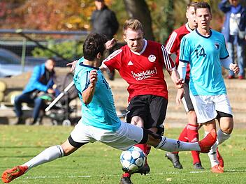 Der Lichtenfelser Daniel Oppel (in Rot) brachte seine Mannschaft mit dem 1:0 auf die Siegerstraße. Die beiden Anschlusstreffer des Forchheimers Andi Mönius (hier grätschend) reichten nicht. Die Jahn-Abwehr um Innenverteidiger Sandro Gumbrecht (re.) machte gegen den Aufsteiger keine gute Figur.  Foto: Sportfoto Zink