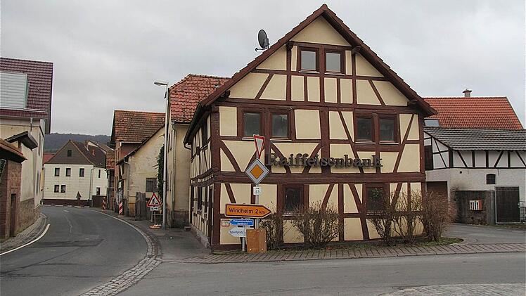 Die Abrissbirne schwebt über der ehemaligen Raiffeisenbankfiliale (vorn mit Fachwerk) und dem dahinter liegenden Anwesen Christ.