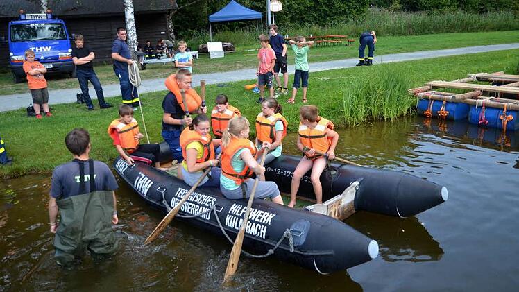 Bastian, Selina, Nadine, Katharina, Elena und Paul probieren erst einmal das Schlauchboot aus. Jakob vom THW erklärt ihnen, wie man mit dem Paddel umgeht.