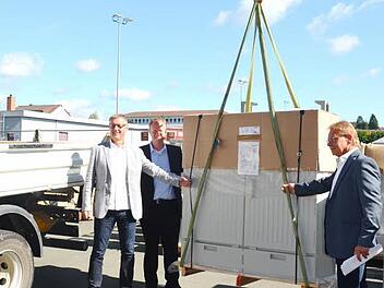 Die Telekom-Experten Achim Fickenscher und Andreas Rudloff sowie Bürgermeister Wolfgang Beiergrößlein (v. l.) verladen das erste von 43 Multifunktionsgehäusen für schnelleres Internet in Kronach. Foto: eh