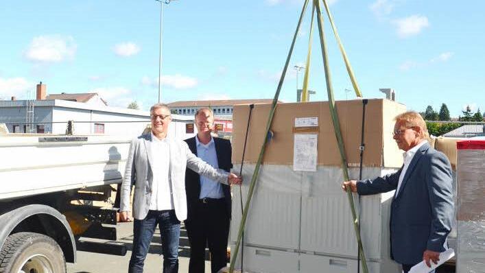 Die Telekom-Experten Achim Fickenscher und Andreas Rudloff sowie Bürgermeister Wolfgang Beiergrößlein (v. l.) verladen das erste von 43 Multifunktionsgehäusen für schnelleres Internet in Kronach. Foto: eh
