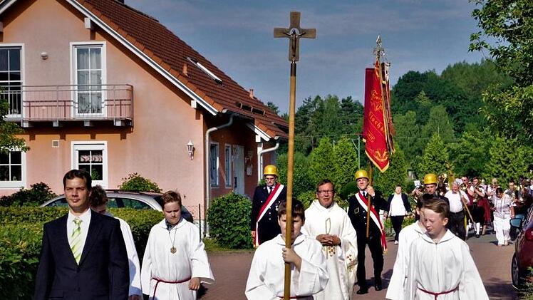 Das 40-jährige Weihejubiläum das St. Johanneskirche in Haßlach bei Kronach wurde mit einer Kirchenparade eingeleitet. Im Vordergrund Kirchenpfleger Stefan Klinger, Pfarrer Hans-Michael Dinkel sowie die Ministranten.  Foto: Gerd Fleischmann