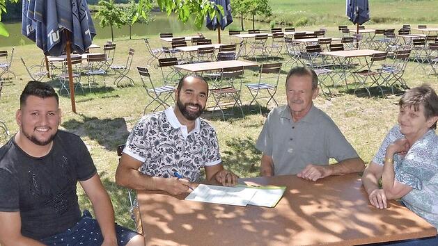 Vertragsunterzeichnung im idyllischen Biergarten: Sami Alijaj (zweiter von links) mit seinem Mitarbeiter Alex Vladulescu sowie Hans und Elfriede Gumbrecht.  Foto: Bernhard Panzer