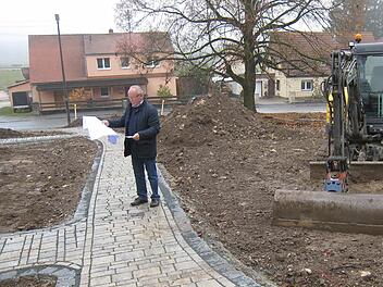 Günther Eichler schaut sich auf der Baustelle am Dreieck um. Er ist Beauftragter der Stadt Gräfenberg und einer der sechs Vorsitzenden der Teilnehmergemeinschaft. Er studiert die Pläne, was alles gemacht wird und hofft, dass noch vor Wintereinbruch asphaltiert werden kann. Foto: privat