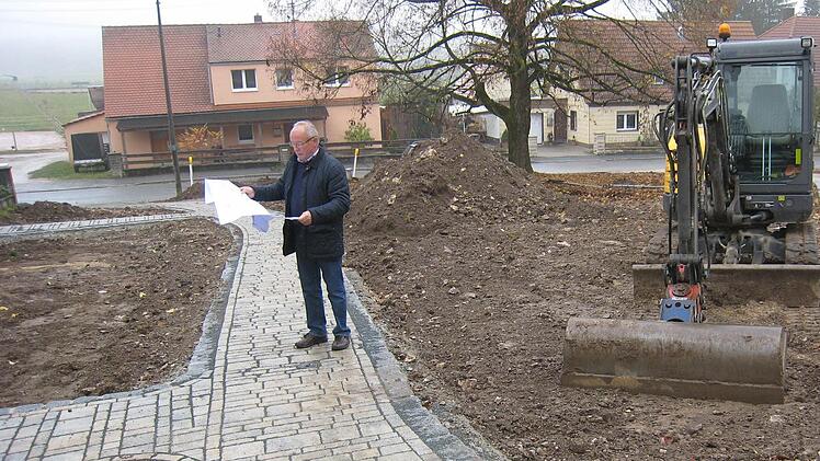 Günther Eichler schaut sich auf der Baustelle am Dreieck um. Er ist Beauftragter der Stadt Gräfenberg und einer der sechs Vorsitzenden der Teilnehmergemeinschaft. Er studiert die Pläne, was alles gemacht wird und hofft, dass noch vor Wintereinbruch asphaltiert werden kann. Foto: privat