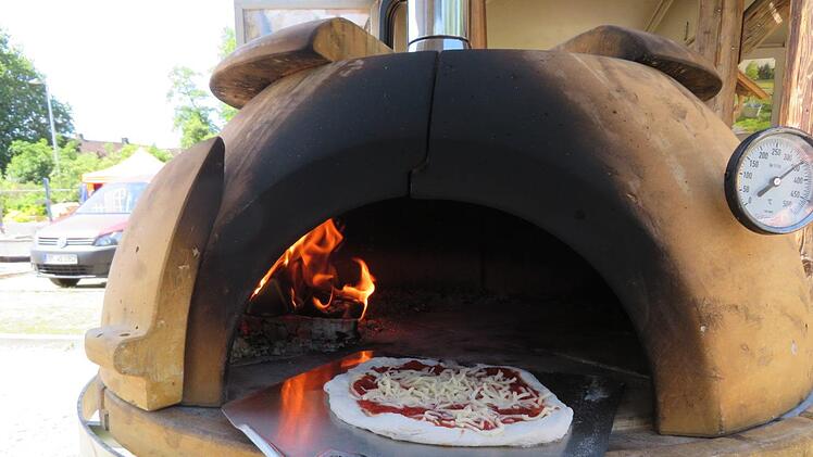 Und hinein damit: die Pizza wird in den Holzbackofen geschoben. Der Clou: dieser ist mobil.