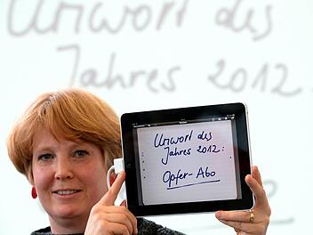 Die Sprachwissenschaftlerin Nina Janich zeigt das Unwort des Jahres "Opfer-Apo". Foto: Arne Dedert/dpa