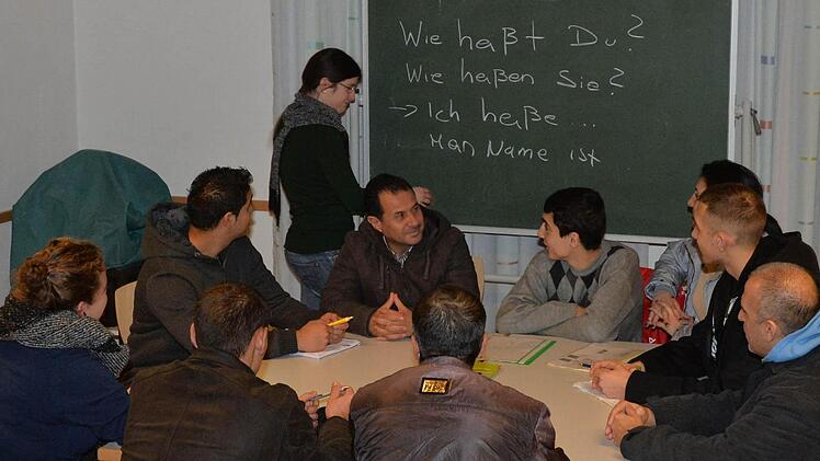 Die Studentinnen Gabrina Mätzke (an der Tafel) und Katja Winter (vorne links) geben Asylbewerbern Deutschunterricht. Foto: Ronald Rinklef