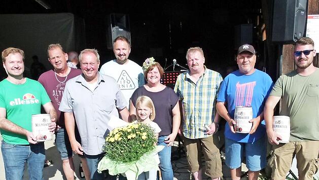 Die Vertreter der drei siegreichen Boccia-Teams und die Gewinnerin der Pflanzentombola Mina (mit Blumenstrau&szlig;), mit Feuerwehrvorsitzendem J&ouml;rg Limmer (Vierter von links), der Vorsitzenden des Gartenbauvereins, Sonja Hofmann (Sechste von links) und B&uuml;rgermeister Volker Schmiechen (Dritter von links) Foto: Werner Oetter