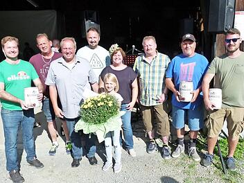 Die Vertreter der drei siegreichen Boccia-Teams und die Gewinnerin der Pflanzentombola Mina (mit Blumenstrauß), mit Feuerwehrvorsitzendem Jörg Limmer (Vierter von links), der Vorsitzenden des Gartenbauvereins, Sonja Hofmann (Sechste von links) und Bürgermeister Volker Schmiechen (Dritter von links) Foto: Werner Oetter