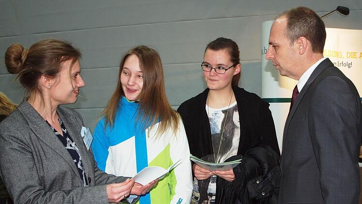 Elisa Fischer und Laura Zillibiller (2. u. 3. v. links) ließen sich am Stand des Versandunternehmens Baur von der Ausbildungsreferentin Doreen Nagel (links) in Gegenwart des Landrats Christian Meißner (rechts) über die Ausbildungsberufe Fotograf und Mediengestalter informieren.