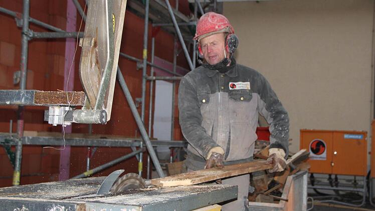 Martin Wolf sägt ein Stück Holz zurecht. Foto: Ulrike Müller