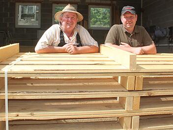 Johann (links) und Stefan Ellner mit einem Stapel Paletten, die sie in ihrem Sägewerk in Weisbrem hergestellt haben. Foto: Matthias Einwag