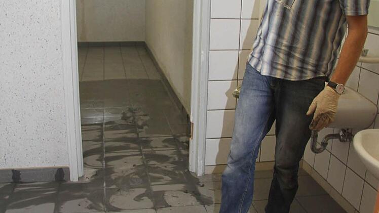 Fredi Mösch verlegt die Fliesen im Sanitärbereich des Hortes.