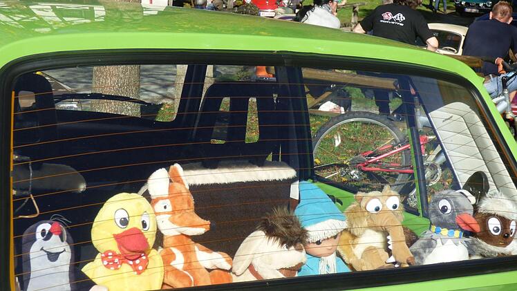 Die Heckscheibe eines Trabis, darin Plüschtierfiguren der einstigen Kinderkultserie des DDR-Fernsehens "Das  Sandmännchen".