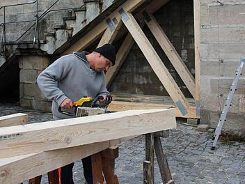 Bauhofmitarbeiter Michael Neidhardt sägt Balken für die Holzkonstruktion im Hintergrund zurecht. Die Treppe muss auf Grund baulicher Mängel gesichert werden. Foto: Alexander Löffler