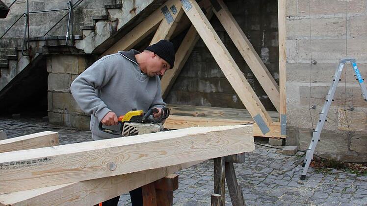 Bauhofmitarbeiter Michael Neidhardt sägt Balken für die Holzkonstruktion im Hintergrund zurecht. Die Treppe muss auf Grund baulicher Mängel gesichert werden. Foto: Alexander Löffler