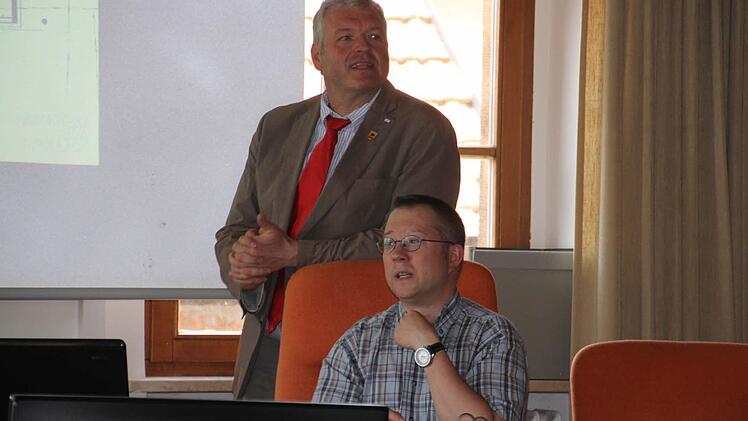 Bürgermeister Jürgen Hennemann und Stefan Hofmann vom Bauamt (von links) zeigen eine Ansicht des neuen Betreuungsgebäudes. Foto: Helmut Will
