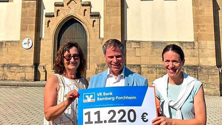 Scheck&uuml;bergabe vor der Pfarrkirche St. Sebastian in Hallerndorf (v.&nbsp;l.): Kirchenpflegerin Anita Volkmuth, Pfarrer Matthias Steffel und Filialleiterin Karin Kropfelder. Gerhard Volkmuth