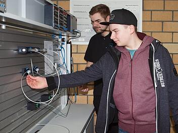Der 14-jährige Schüler Timo Hümmer (vorne) der Realschule Burgkunstadt, der Landmaschinenmechatroniker werden möchte, lässt sich eine pneumatische Schaltung erklären. Foto: Alfred Thieret