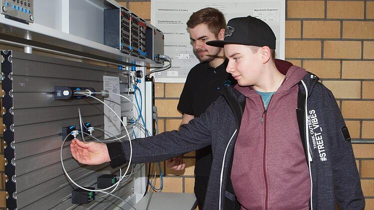 Der 14-jährige Schüler Timo Hümmer (vorne) der Realschule Burgkunstadt, der Landmaschinenmechatroniker werden möchte, lässt sich eine pneumatische Schaltung erklären. Foto: Alfred Thieret