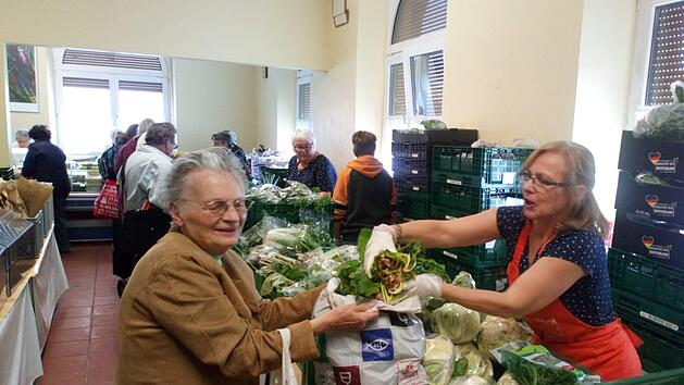 Hilfe bei der N&uuml;rnberger Tafel: Mitarbeiterin Claudia Heinz macht der Seniorin Wilhelmine Buchner die T&uuml;te voll. Immer mehr Rentner gehen zur Tafel. Foto: Fabio Cavallini